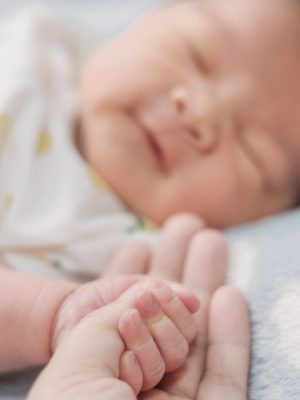 close-up hand the asian New born baby in the hand of mother.